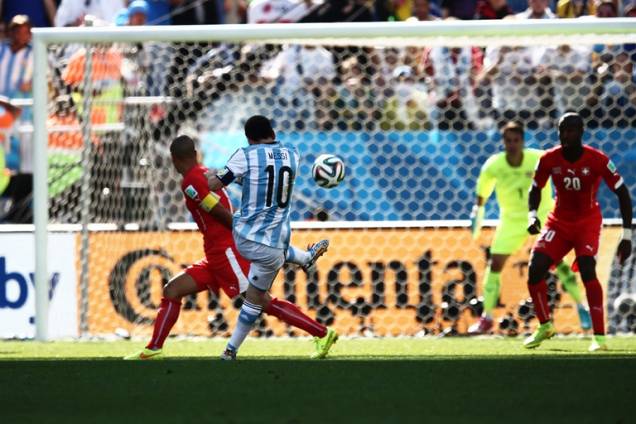 	Messi chuta para o gol em partida contra a Suíça: vitória no sufoco