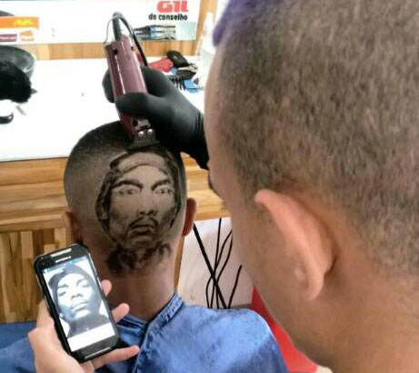 O barbeiro observa retratos para conseguir reproduzir a imagem na cabeça dos clientes O barbeiro observa retratos para conseguir reproduzir a imagem na cabeça dos clientes