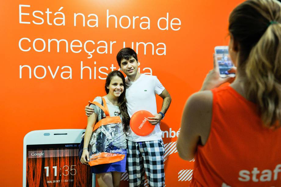 Visitantes do stand posam para fotos e levam seus presentes