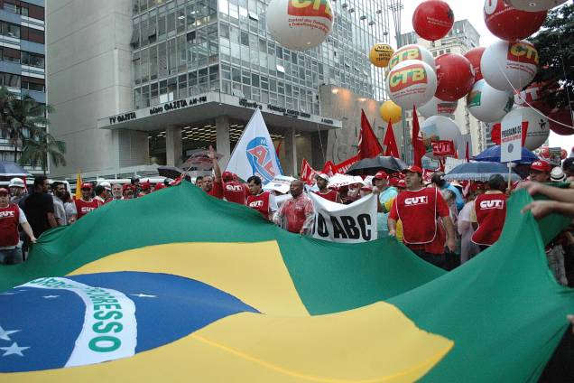 Manifestantes abrem a bandeira do Brasil durante a passeata na Paulista