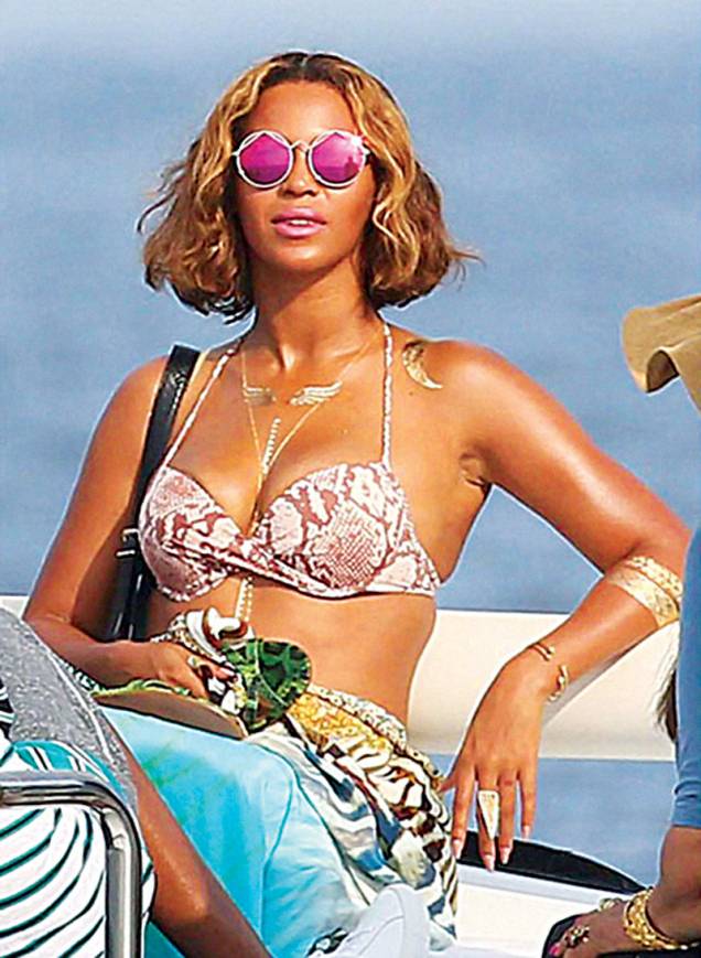 	A cantora Beyoncé usa colares, braceletes e desenhos variados durante suas férias