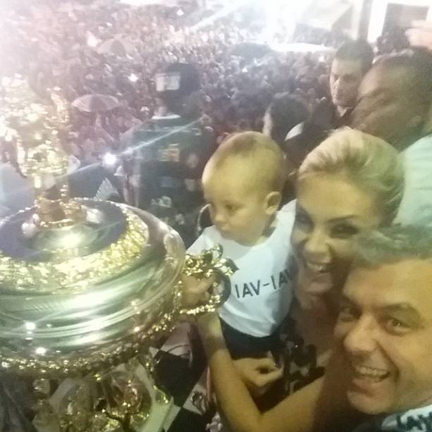 Ana Hickmann, o marido e o filho tocam o troféu da campeã