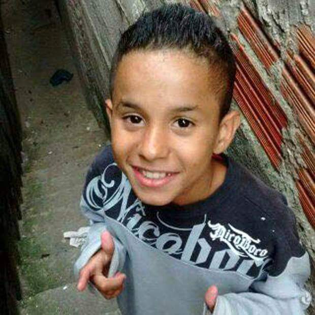 Imagem mostra o menino Biel, de 11 anos, vestindo agasalho cinza e sorrindo