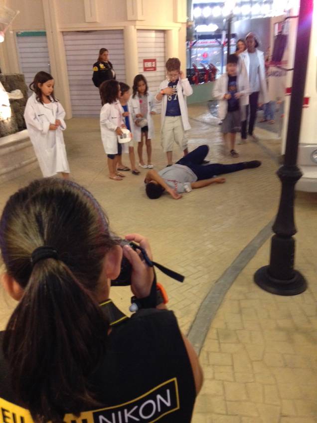 	Enquanto algumas crianças  protagonizam um atendimento medico, outras fazem o papel de fotógrafo