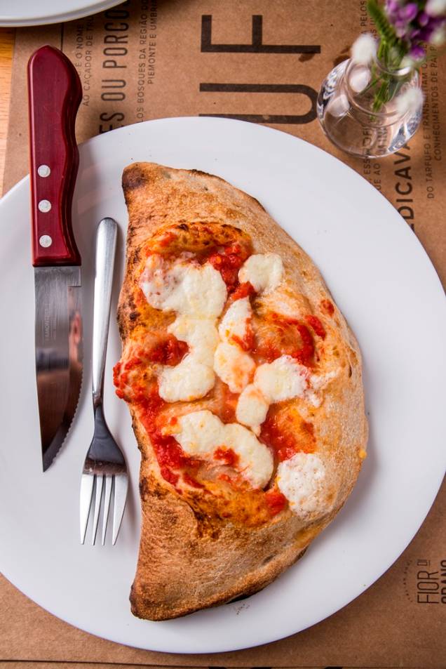 Fechado como um pastelão, o calzone leva recheio de presunto, mussarela, tomate e creme de alcachofra