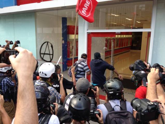 	Manifestantes mascarados picham e quebram vidraça de agência bancária na Avenida Paulista neste sábado (7)