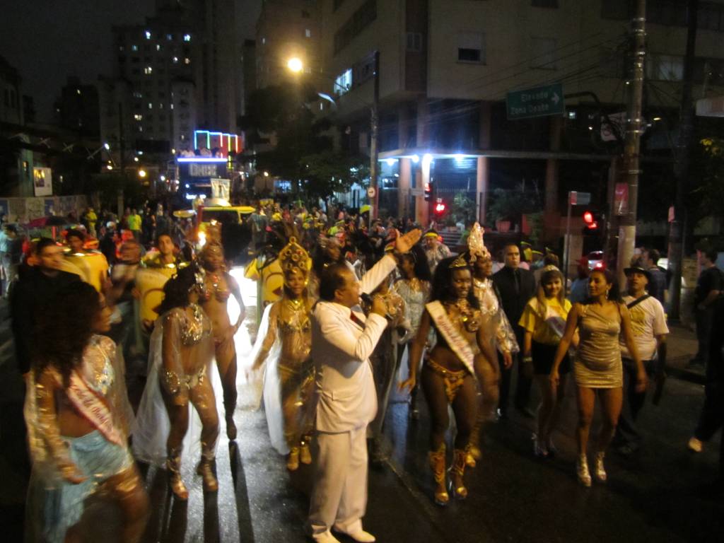 Candinho, ao centro, de branco, anima o p&uacute;blico entre musas e princesas da Banda