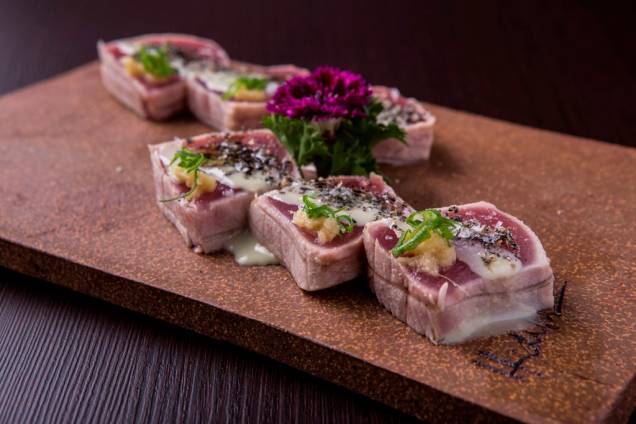 As fatias de atum selado são temperadas com molho de wassabi e gergelim, no Huto Izakaya