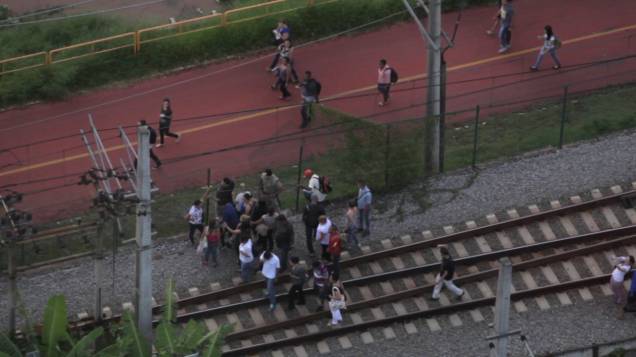 	Passageiros caminham pela linha da CPTM próximo à estação Pinheiros após falha técnica em trem
