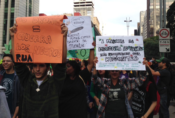 Jovens seguram cartazes durante a Marcha