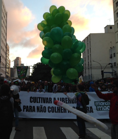 Na frente da passeata, alguns grandes cartazes diziam "cultivar a liberdade para não colher a guerra"