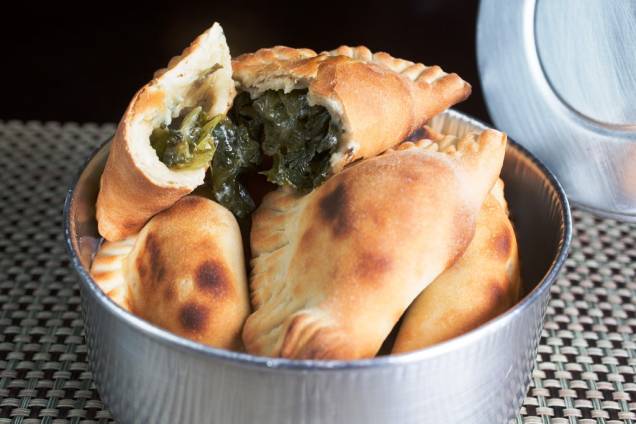 Para beliscar, a porção de pasteizinhos assados, os panzotti, vem numa marmita de alumínio Para beliscar, a porção de pasteizinhos assados, os panzotti, vem numa marmita de alumínio