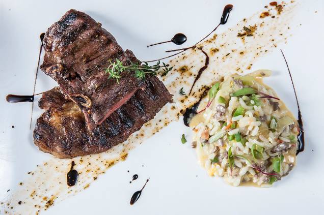 Grelhado com precisão, o assado de tira tem o acompanhamento do arroz dos pampas Grelhado com precisão, o assado de tira tem o acompanhamento do arroz dos pampas