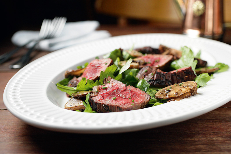 Tagliata de filé-mignon servida com cogumelo portobello e salada de rúcula