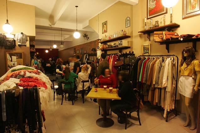 Araras de roupas usadas dividem espaço com as mesas do endereço Araras de roupas usadas dividem espaço com as mesas do endereço