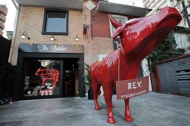 O reluzente touro vermelho Rex fica na entrada da loja