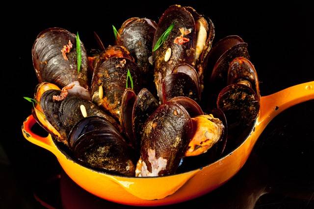Frigideira de Mexilhões de areia puxados em vinho branco com sugo de tomates, Jamom serrano e pinólis