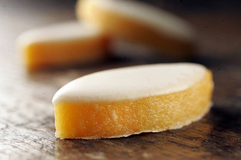 Calisson: feito de amêndoa, laranja e melão e em formato de losango Calisson: feito de amêndoa, laranja e melão e em formato de losango