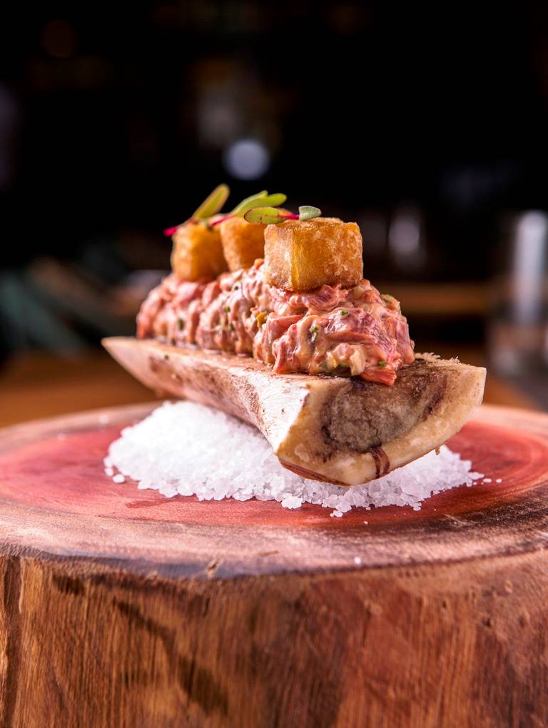 O ótimo steak tartare é montado num osso com pedaços de tutano O ótimo steak tartare é montado num osso com pedaços de tutano