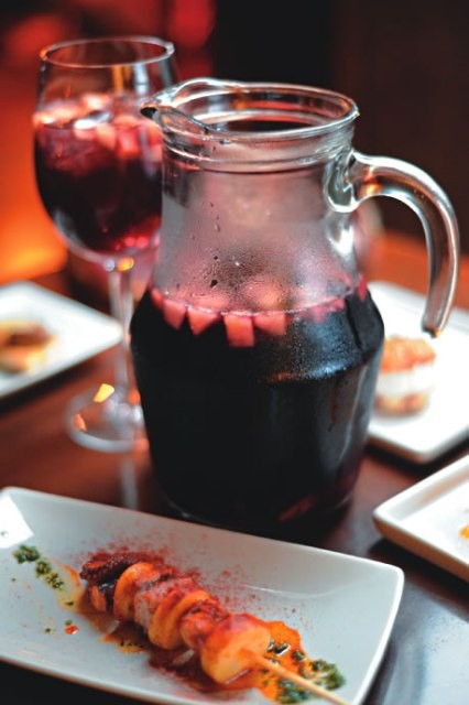 Jarra de sangria ao lado do tira-gosto de polvo com batata: alma espanhola Jarra de sangria ao lado do tira-gosto de polvo com batata: alma espanhola