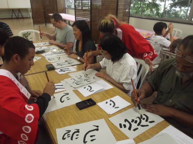 participantes praticando o "shodô" que significa "caligrafia japonesa"