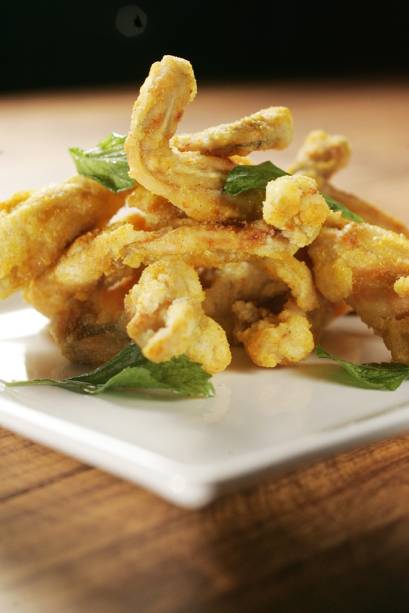 Rã empanada no polvilho com curry amarelo coreano, chamada de curry fried frog