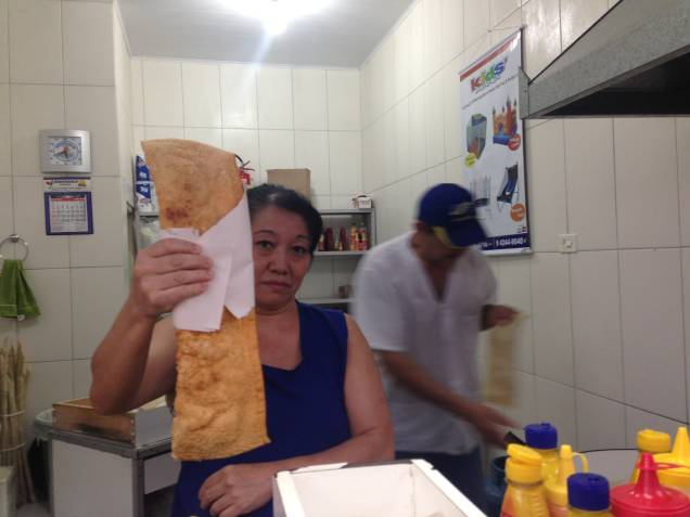 	A pasteleira Sueli Oshiro segura o pastel especial, que mede cerca de meio metro