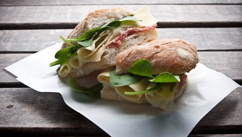 O sanduíche de rúcula, copa e queijo emmental é montado no pão ciabatta