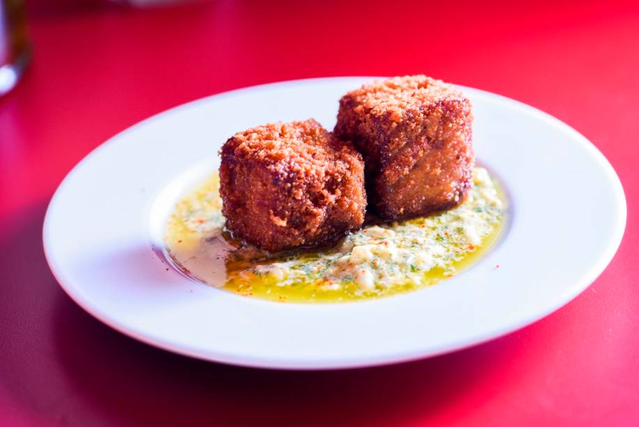 O par de croquetes de pé de porco com linguiça prepara o paladar para o próximo gole