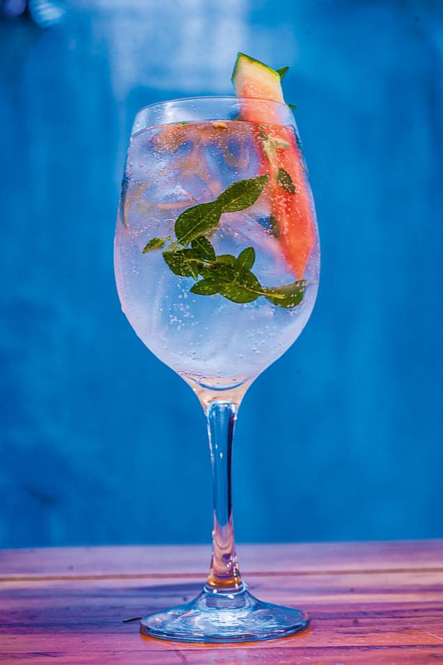 O drinque fresh basil leva gim, tônica, manjericão e uma fatia de melancia O drinque fresh basil leva gim, tônica, manjericão e uma fatia de melancia