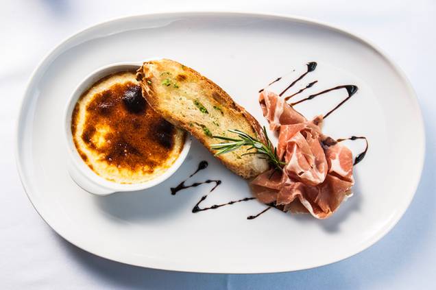 O creme brûlé ganha uma versão salgada de parmesão coberta por compota de pera O creme brûlé ganha uma versão salgada de parmesão coberta por compota de pera