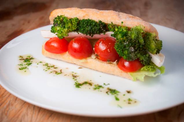 Quase vegetariano, o lanche de queijo brie, tomate-cereja, brócolis e alface ao molho pesto é montado na ciabatta