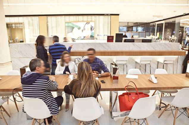 No quiosque no Shopping JK Iguatemi, há uma mesa comunitária para dezesseis pessoas