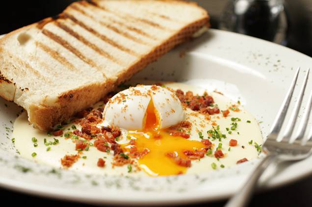 Cozido para ficar com gema mole, o ovo vem com creme de batata e crisp de bacon