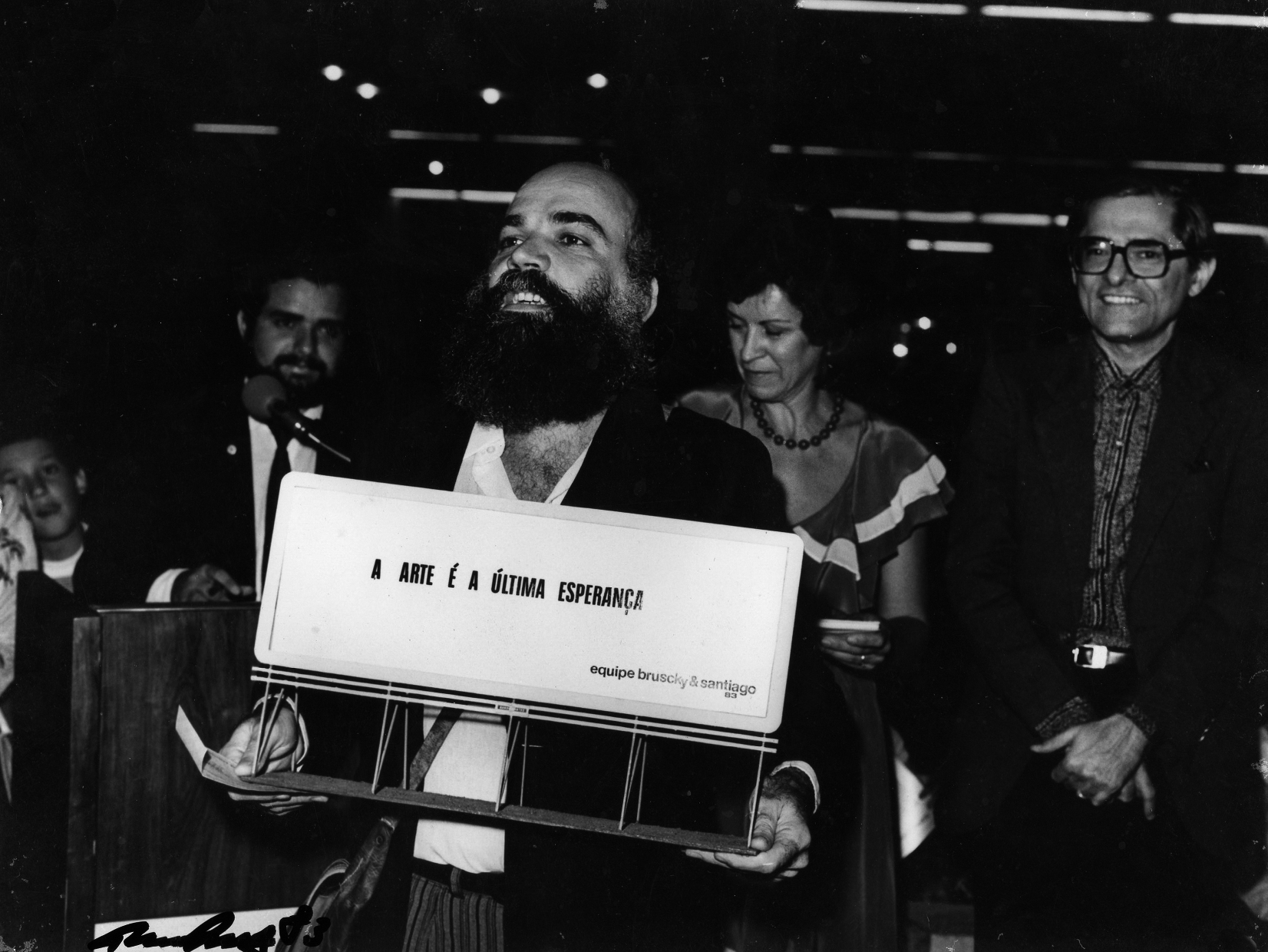 paulo-bruscky-a-arte-e-a-ultima-esperanca-registro-de-acao-no-xxxvi-salao-de-artes-plasticas-de-pernambuco-1983-fotografia-ed-vintage-18-x-23-5-cm.jpeg