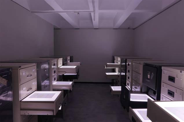Obra é montada com documentos dentro de gavetas iluminadas de arquivos antigos Obra é montada com documentos dentro de gavetas iluminadas de arquivos antigos