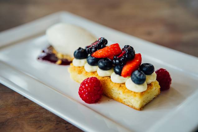 Sobremesa: brownie de chocolate branco enfeitado com frutas vermelhas e sorvete de iogurte Sobremesa: brownie de chocolate branco enfeitado com frutas vermelhas e sorvete de iogurte