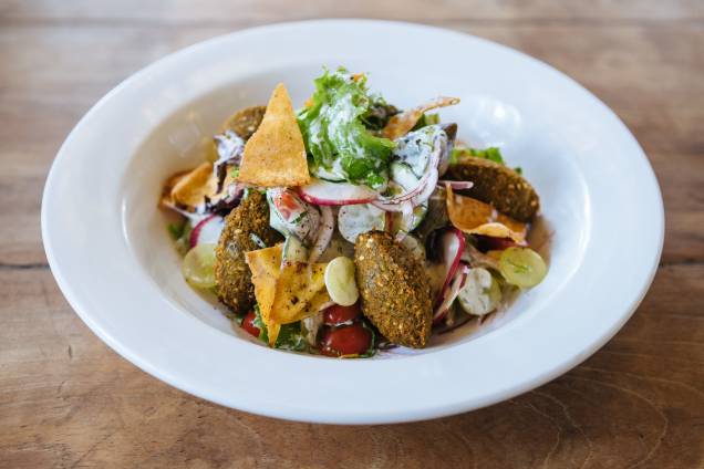 Faláfel: servido sobre salada de folhas, rabanete, pepino, cebola-roxa, uva e torrada ao molho de iogurte Faláfel: servido sobre salada de folhas, rabanete, pepino, cebola-roxa, uva e torrada ao molho de iogurte