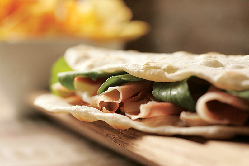 Piadina de presunto cru, lascas de queijo grana padano, cogumelo-de-paris e rúcula