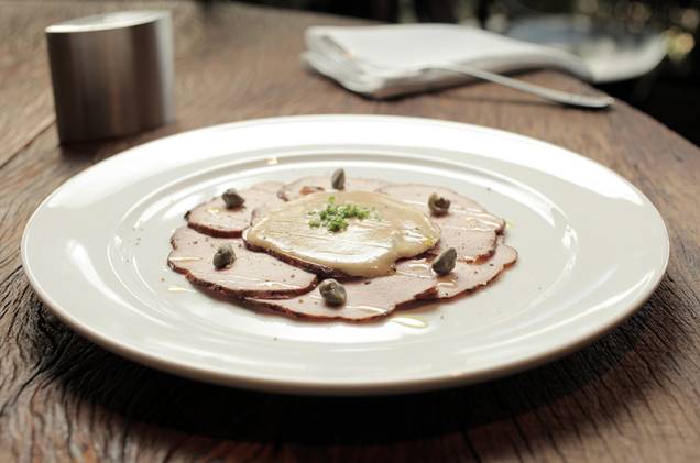 O vitelo tonnato vem regado com maionese de atum e alcaparra