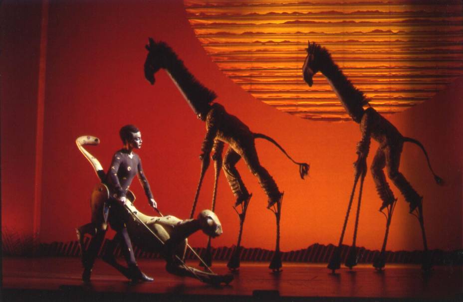 Girafas e um guepardo andam pela savana durante a apresentação da música "O Círculo da Vida" (The Tree of Life), que abre o espetáculo.