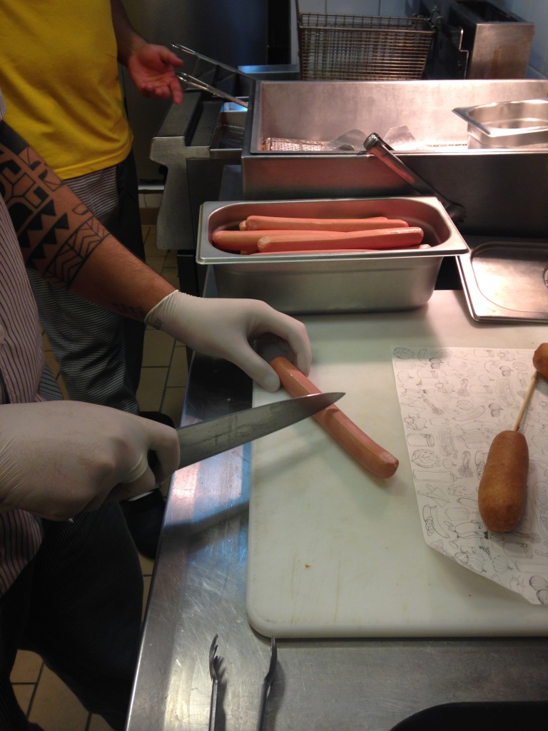 Primeiro passo: a salsicha 100% bovina é cortada ao meio (Foto: Helena Galante)