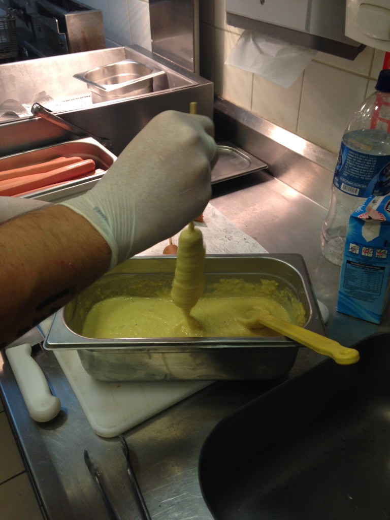 Espetada num palito, a salsicha depois é mergulhada numa massa cremosa de milho (Foto: Helena Galante)
