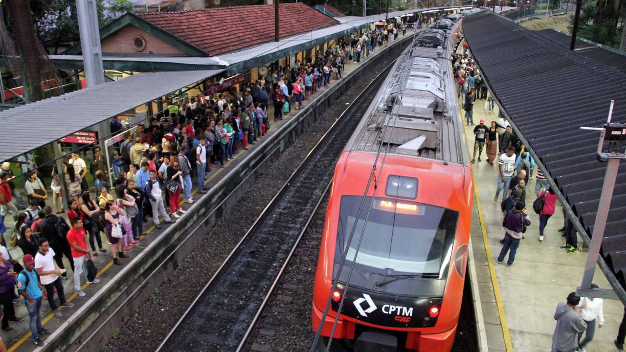 A imagem mostra uma estação da CPTM repleta de passageiros e um trem na plataforma