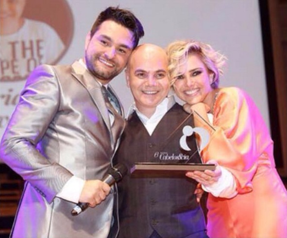 Adriano Oliveira, ao centro, recebe prêmio de André Sartori e Nathália Rodrigues (Foto: Reprodução/Instagram)