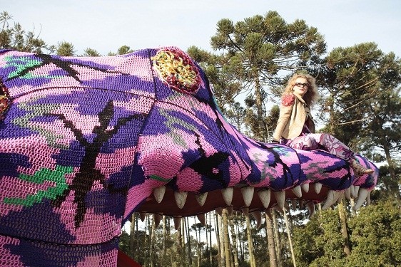 A artista Agata Olek em cima de um jacaré feito de crochê: obra integra a Mostra Sesc de Artes
