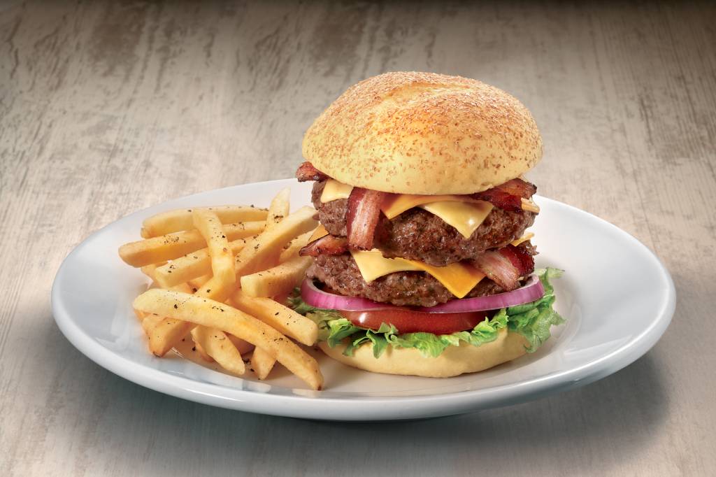 Big apple, do Applebees: dois bifões de 200 gramas, queijo cheddar, quatro fatias de bacon, cebola-roxa, alface, tomate e picles