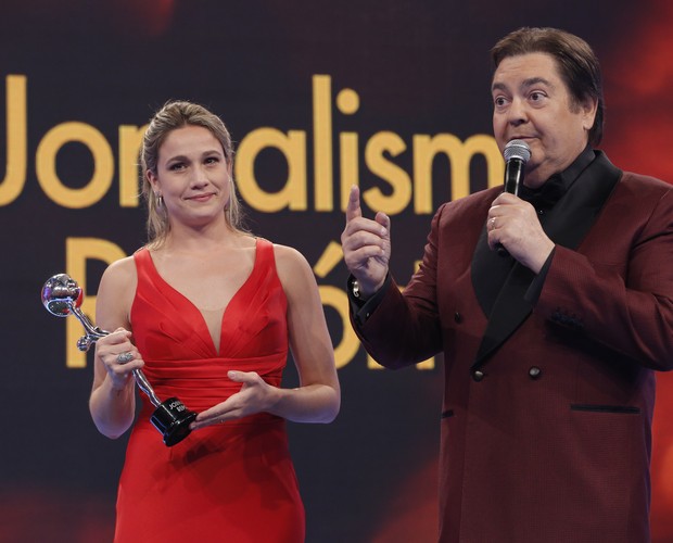 A jornalista Fernanda Gentil recebe prêmio do apresentador Fausto Silva