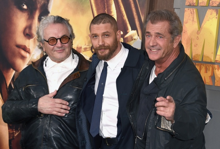 Sob os holofotes: Gibson apareceu de surpresa na pré-estreia de Mad Max e posou ao lado do diretor George Miller e do ator Tom Hardy
