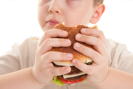 Imagem mostra criança segurando sanduíche